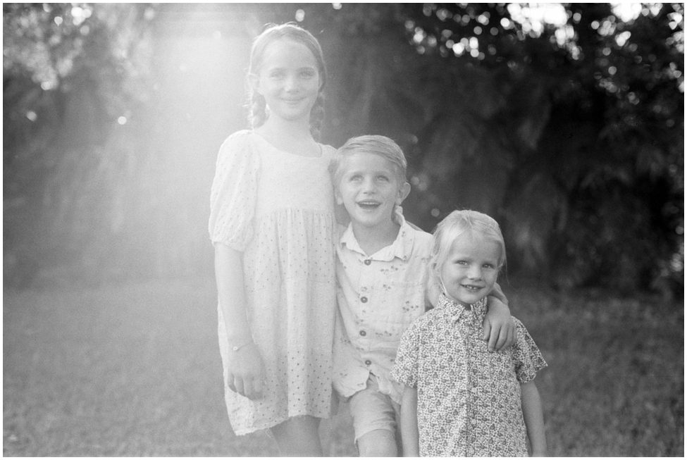 Siblings all together smiling at the camera for their Family Vacation Photos Taken in Black and white