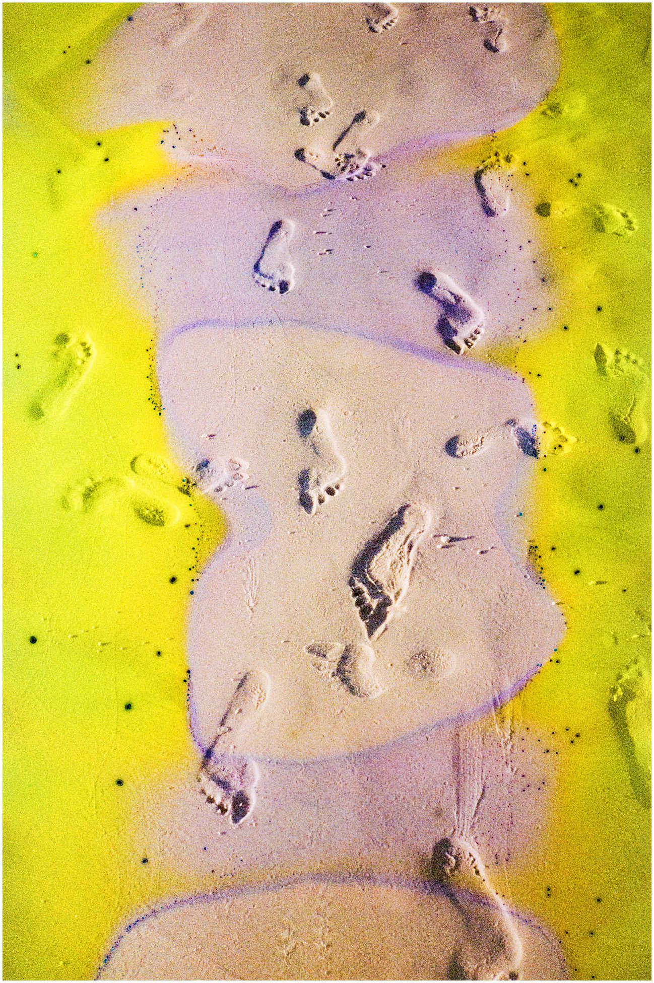 A souped film image of feet in the sand and the yellow food coloring affect the sides of it