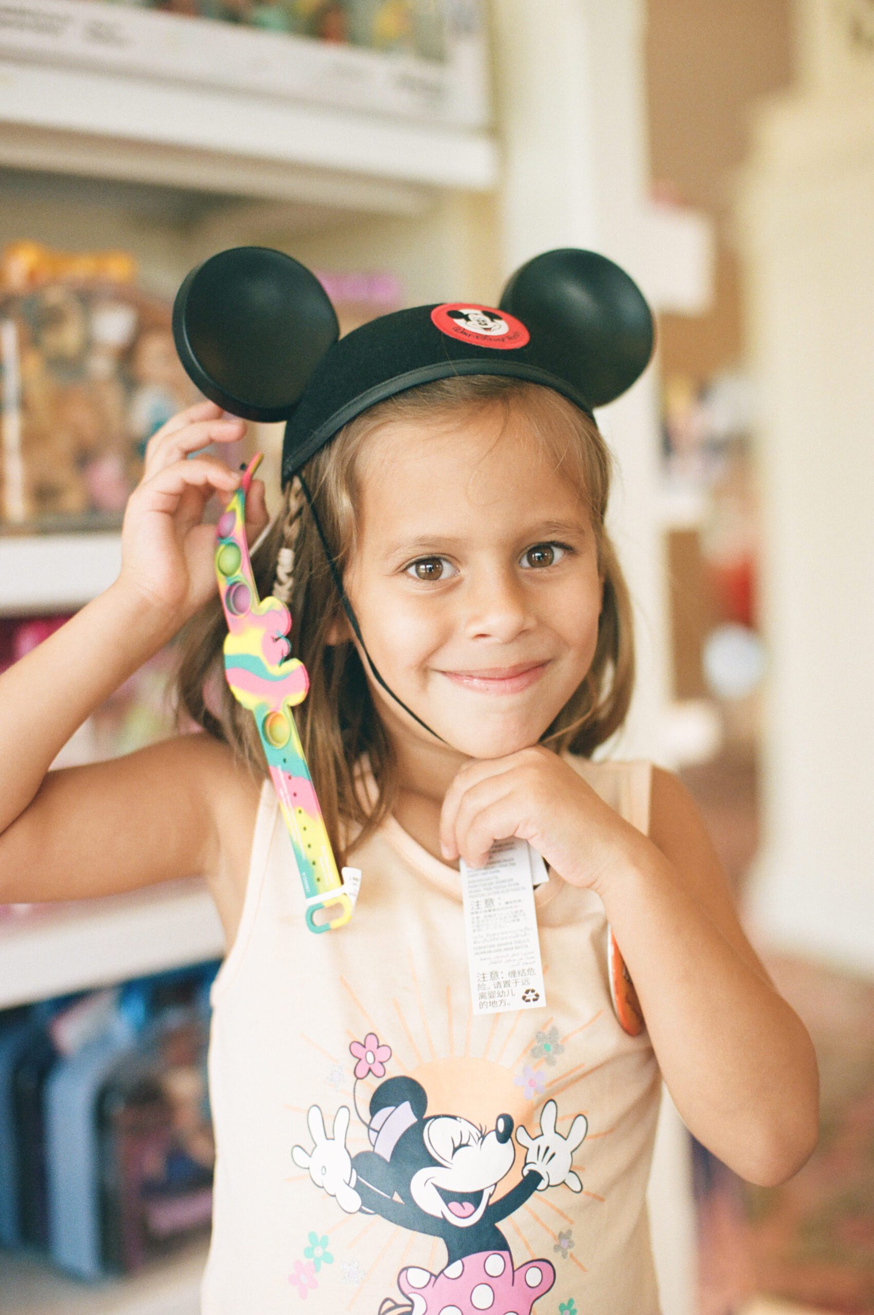 Photo of a 7 year old girl at Walt Disney World Wearing mickey mouse ears in the gift shop