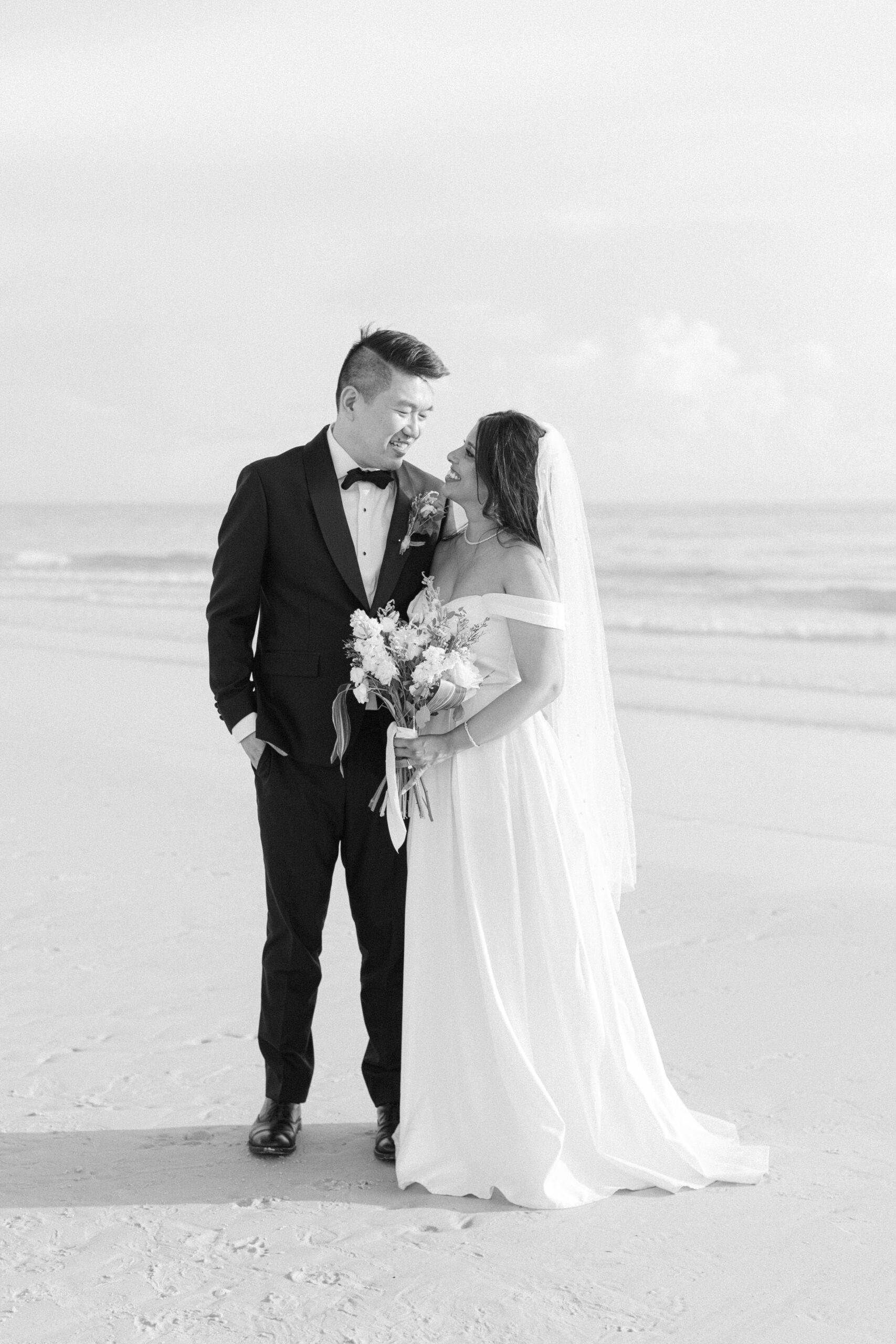a couple who was just married at the Four Seaons Naples getting their portraits taken on the beach